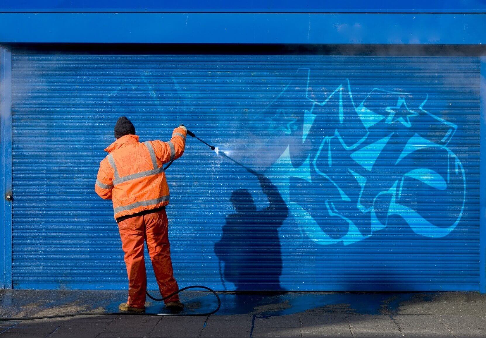 Graffiti removal and cleaning in progress by a skilled graffiti hygiene technician.